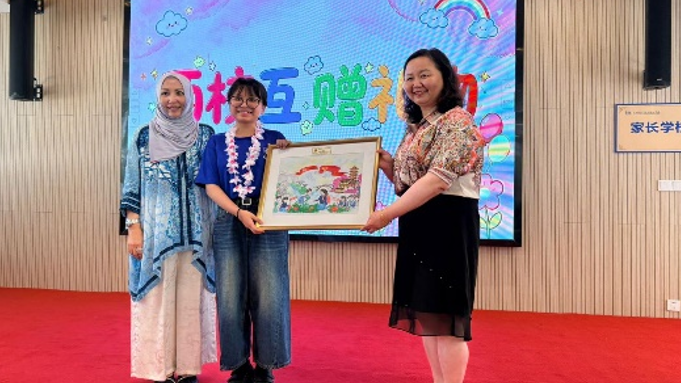 Receiving a commemorative gift during a cultural exchange event.